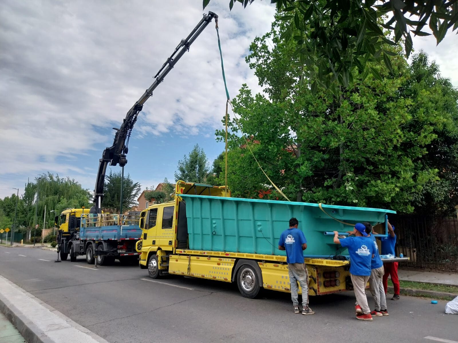 Camión pluma de ALB-KEV instalando el casco de una piscina de fibra de vidrio en una calle residencial de la Región Metropolitana